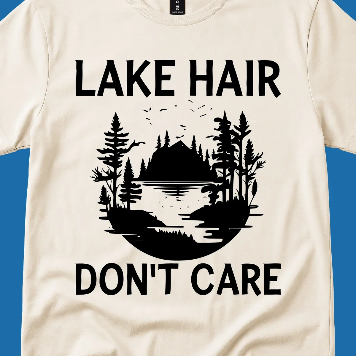 Lake Hair Don't Care design featuring a silhouette of a lake, trees, and mountains.