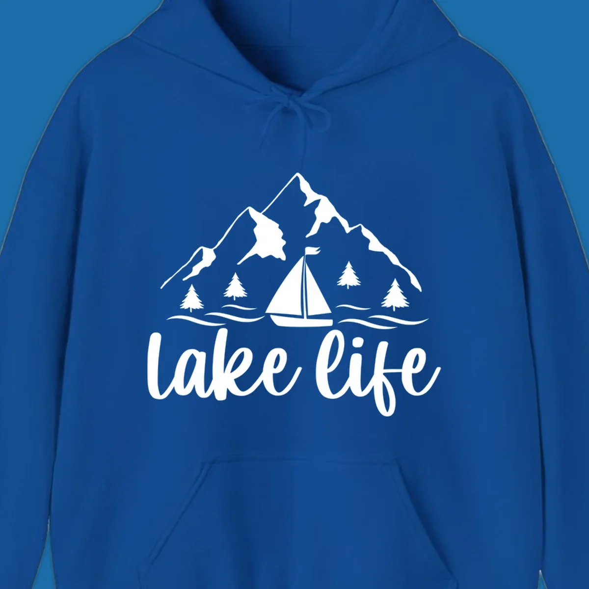 Lake life mountain sailboat scenic design with mountains, trees, sailboat, and text.