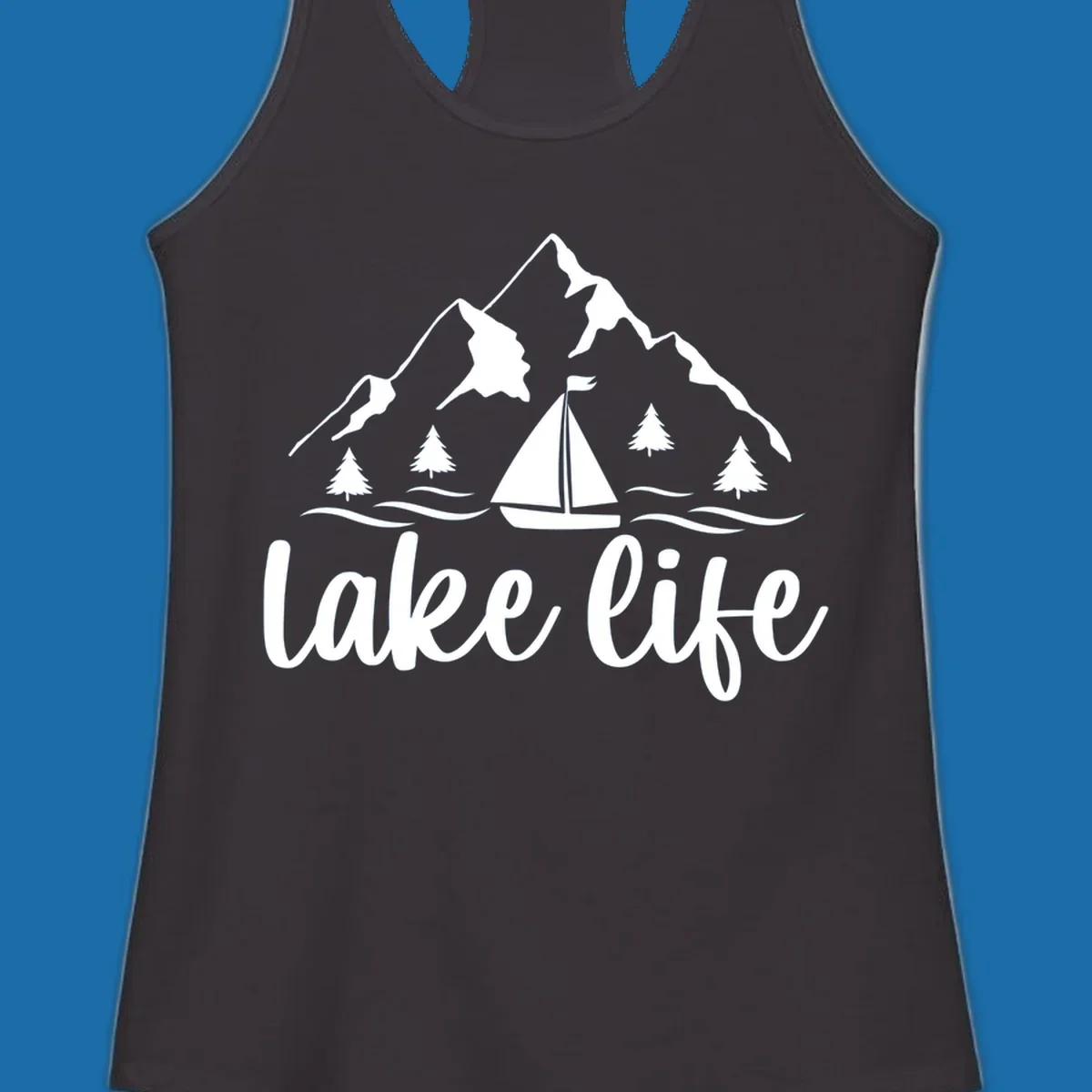 Lake life mountain sailboat scenic design with mountains, trees, sailboat, and text.