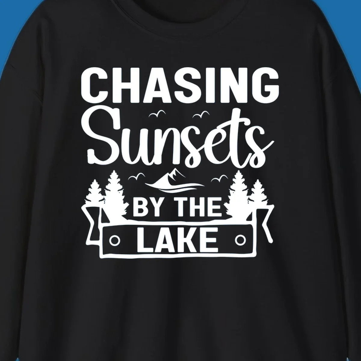 Chasing sunsets by the lake design with text, trees, mountains, and birds.