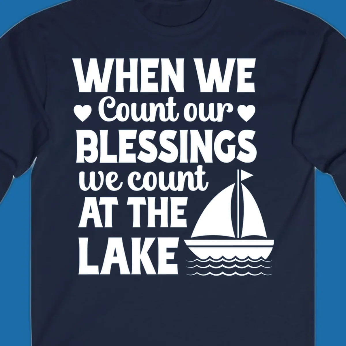 Text reads 'When We Count Our Blessings We Count At The Lake' with a sailboat graphic, lake-life-blessings design.