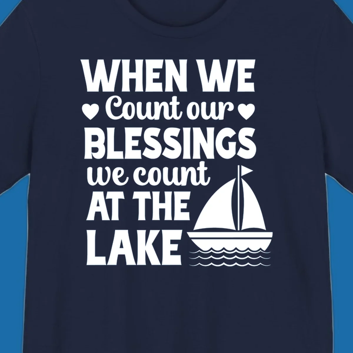 Text reads 'When We Count Our Blessings We Count At The Lake' with a sailboat graphic, lake-life-blessings design.