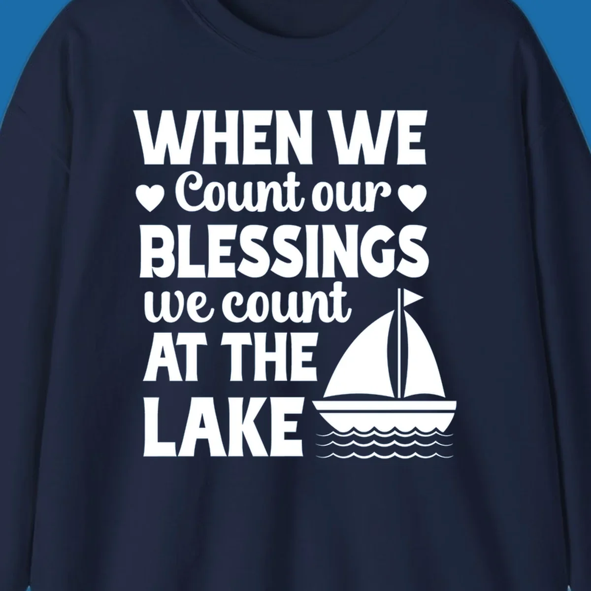 Text reads 'When We Count Our Blessings We Count At The Lake' with a sailboat graphic, lake-life-blessings design.