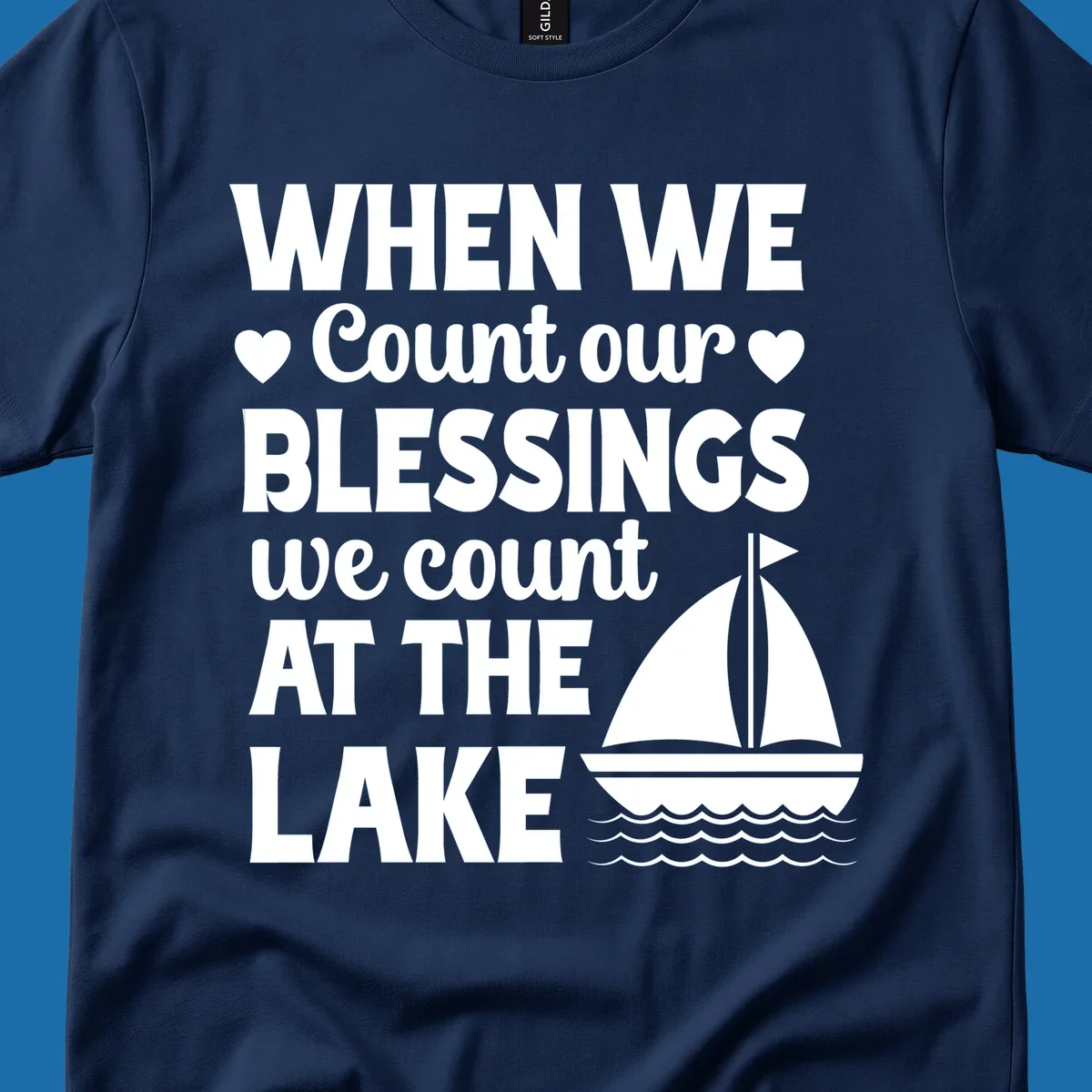 Text reads 'When We Count Our Blessings We Count At The Lake' with a sailboat graphic, lake-life-blessings design.