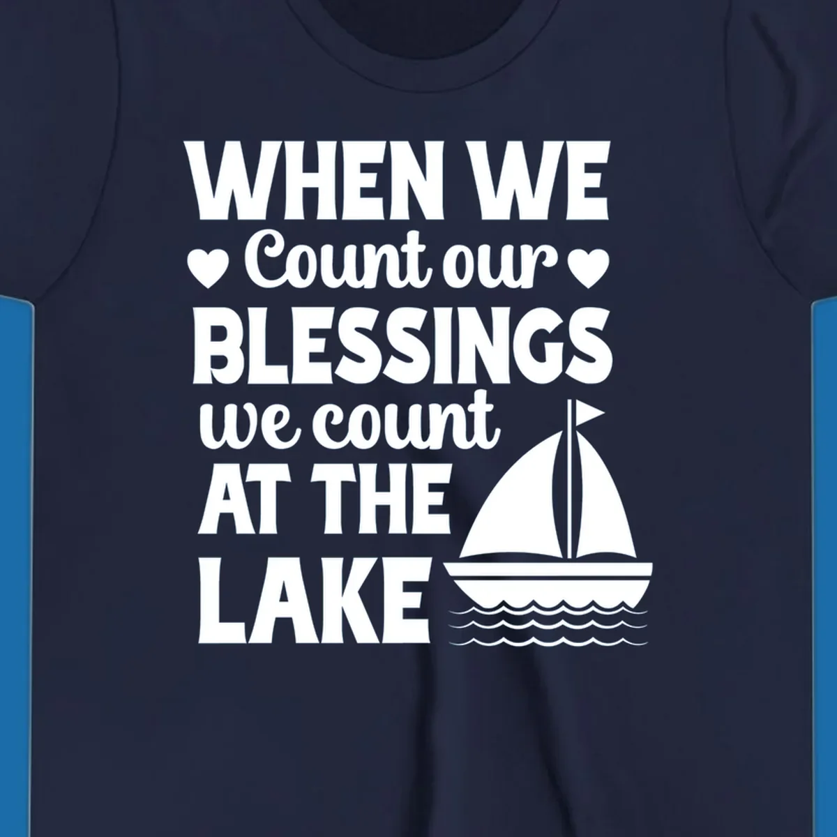 Text reads 'When We Count Our Blessings We Count At The Lake' with a sailboat graphic, lake-life-blessings design.