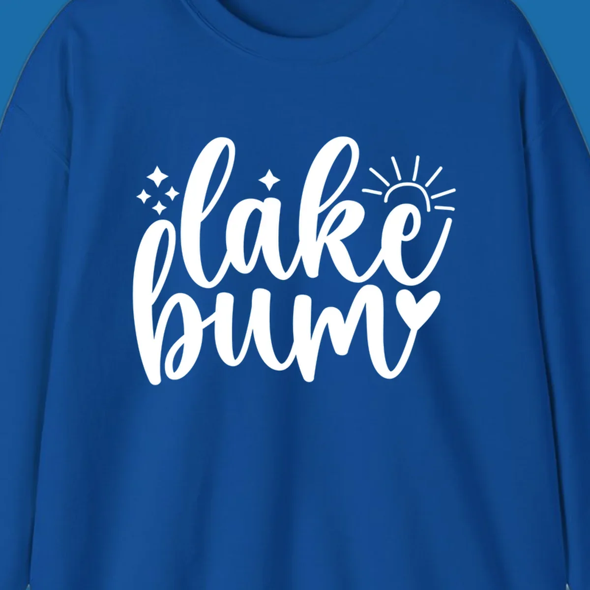 Lake bum text design with sun, sparkles, and heart graphic.