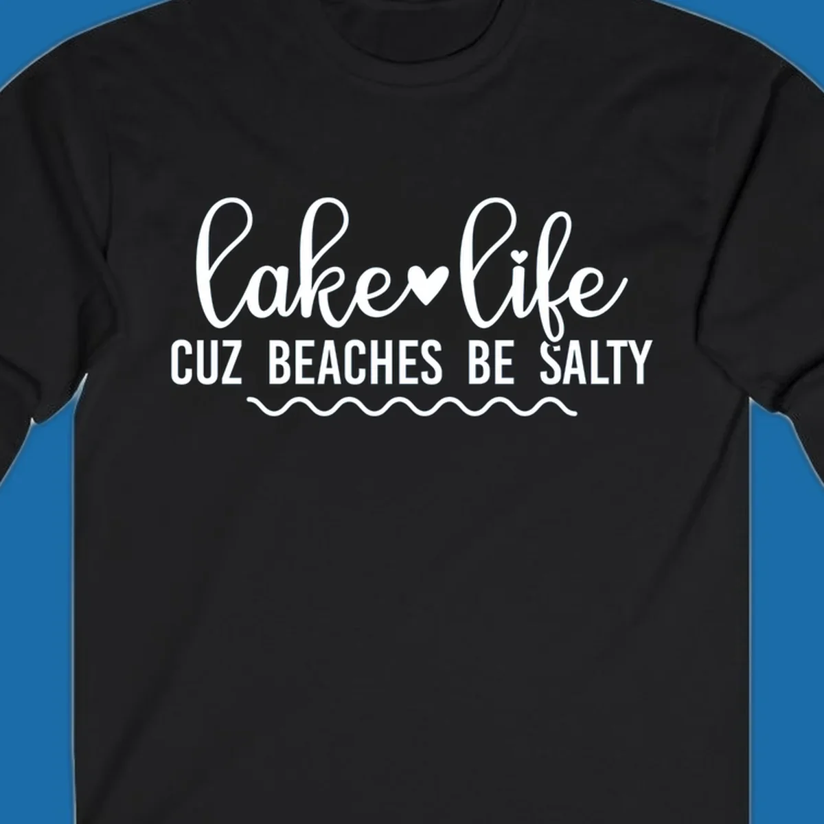 Lake life cuz beaches be salty text design with heart and wavy lines.