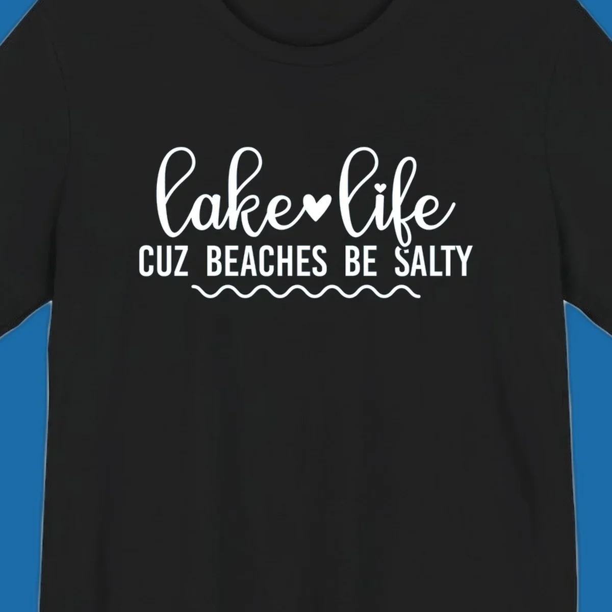 Lake life cuz beaches be salty text design with heart and wavy lines.
