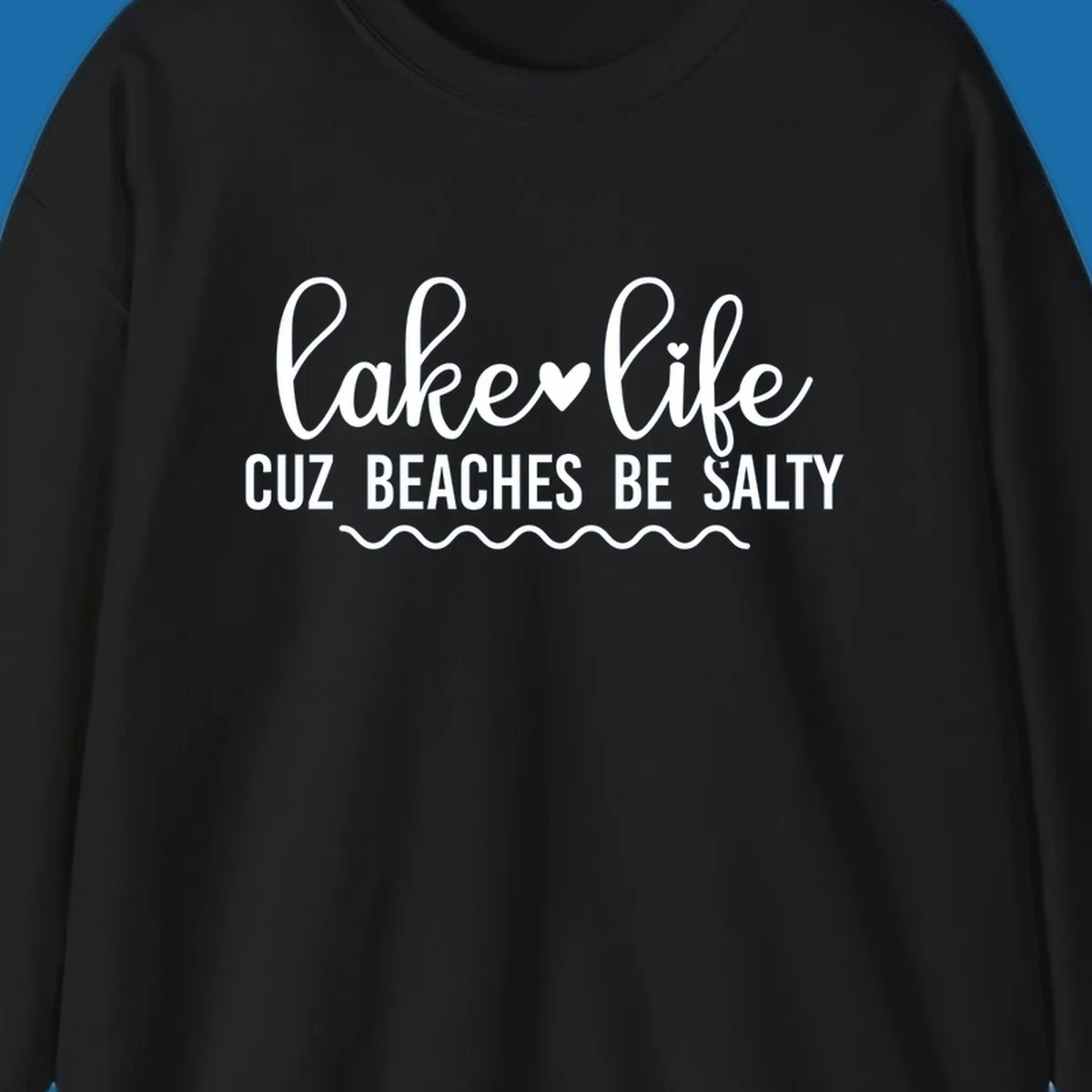 Lake life cuz beaches be salty text design with heart and wavy lines.