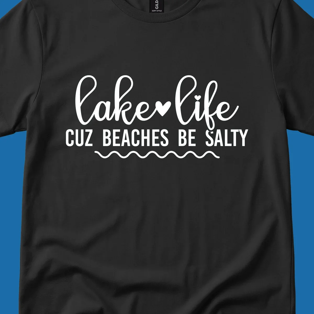 Lake life cuz beaches be salty text design with heart and wavy lines.