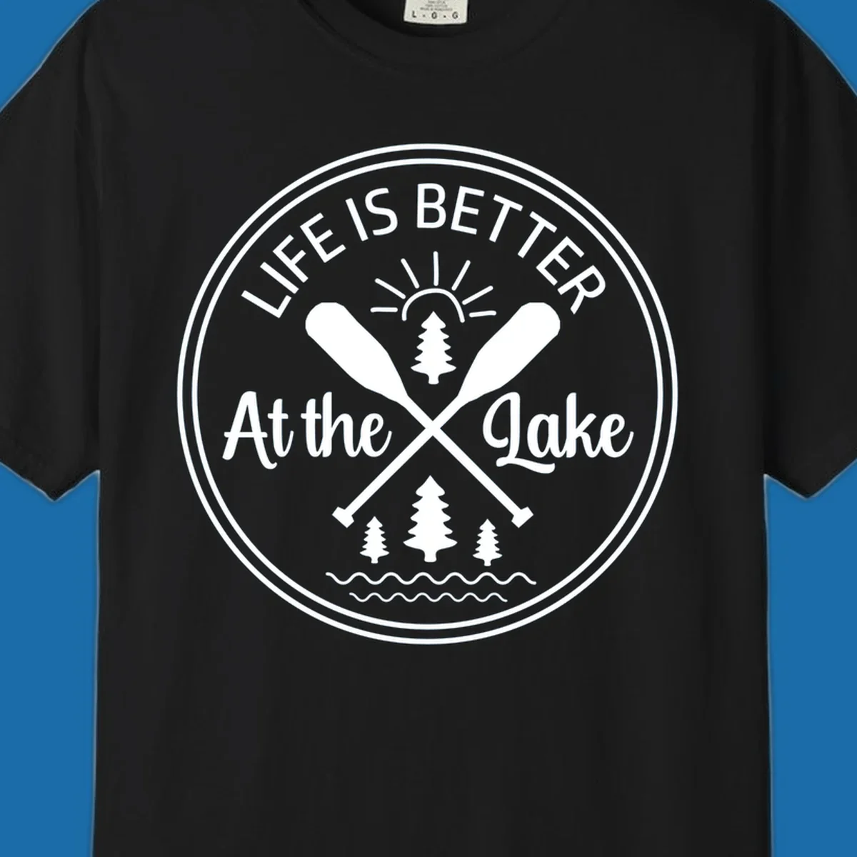 Life is better at the lake circular badge with oars, trees, sun, and waves.