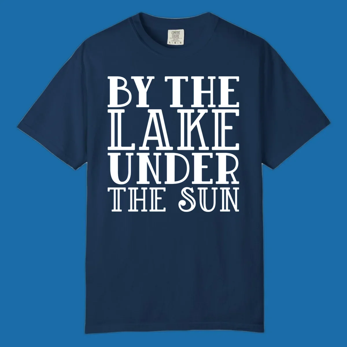 Text design 'BY THE LAKE UNDER THE SUN' in white serif font.