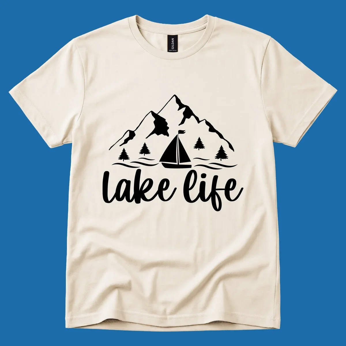 Lake life mountain sailboat scenic design with mountains, trees, sailboat, and text.
