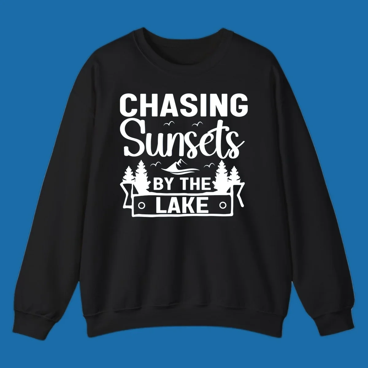 Chasing sunsets by the lake design with text, trees, mountains, and birds.