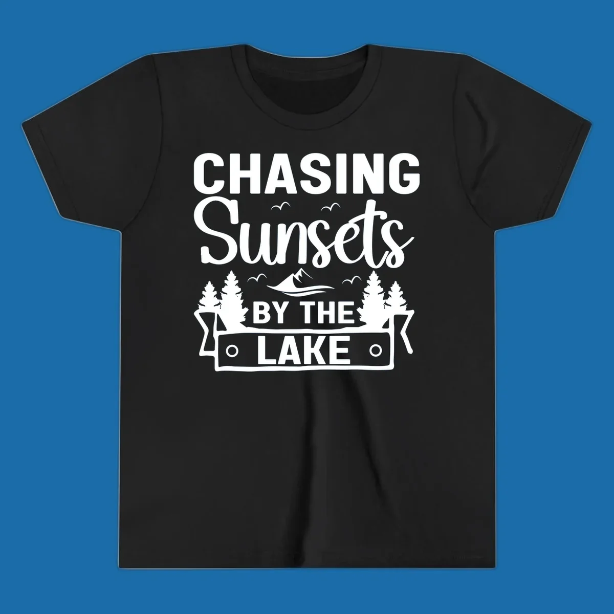 Chasing sunsets by the lake design with text, trees, mountains, and birds.