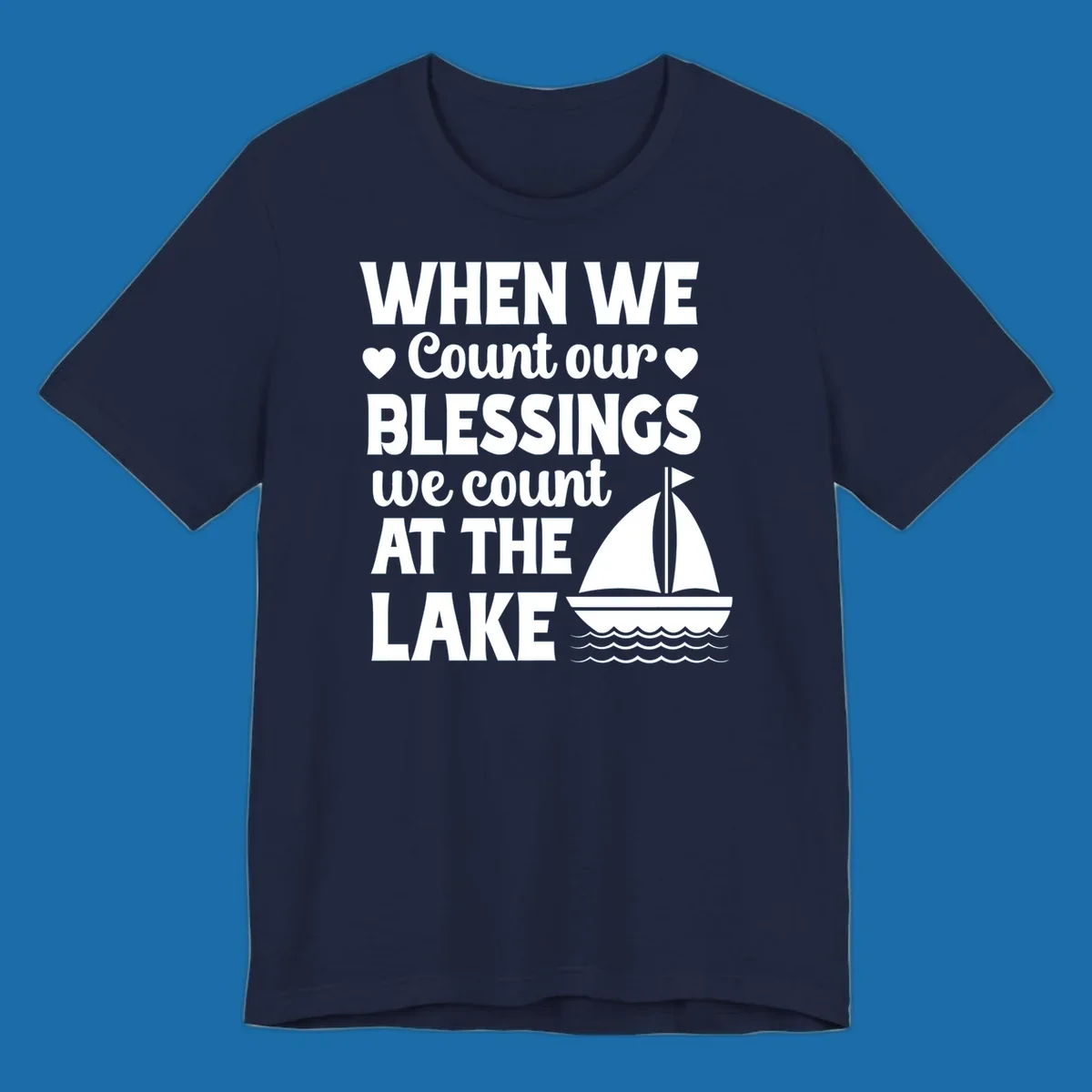 Text reads 'When We Count Our Blessings We Count At The Lake' with a sailboat graphic, lake-life-blessings design.