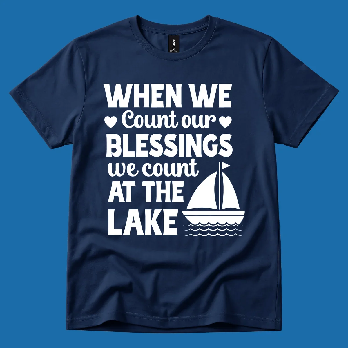 Text reads 'When We Count Our Blessings We Count At The Lake' with a sailboat graphic, lake-life-blessings design.
