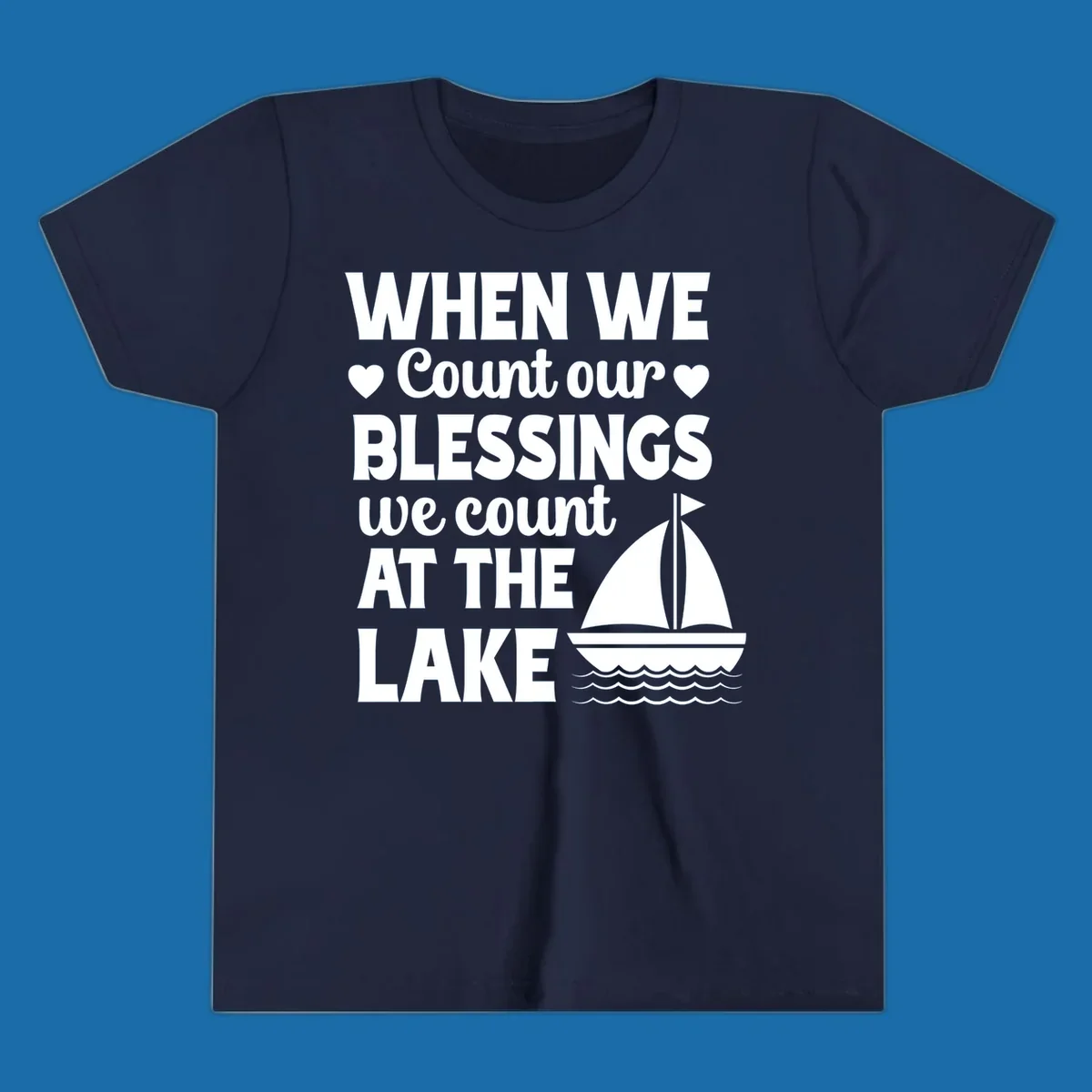 Text reads 'When We Count Our Blessings We Count At The Lake' with a sailboat graphic, lake-life-blessings design.