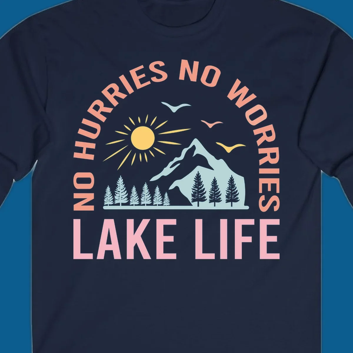 Lake life scenic design with mountains, sun, trees, and no worries text.