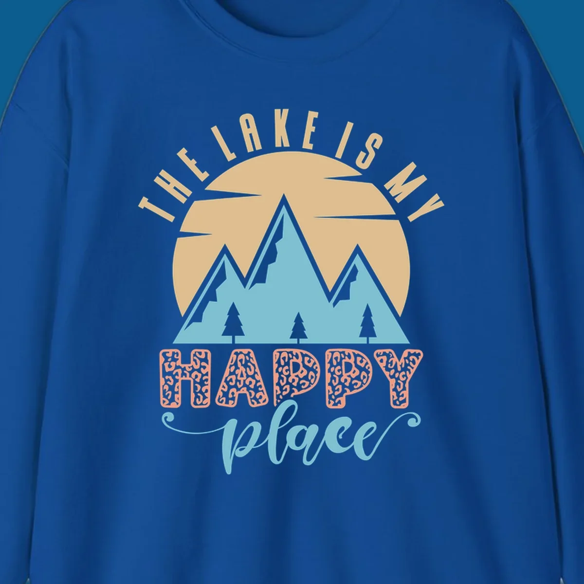 Illustration of mountains and sun with text 'The Lake Is My Happy Place' and leopard print.