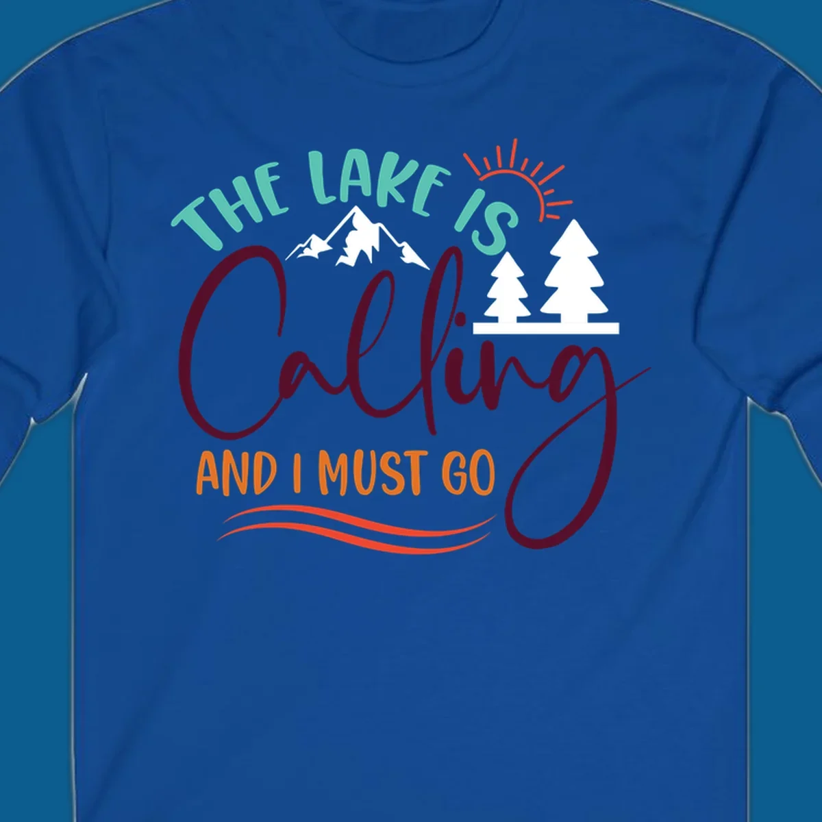 The Lake Is Calling And I Must Go nature graphic with mountains, trees, and sun rays.