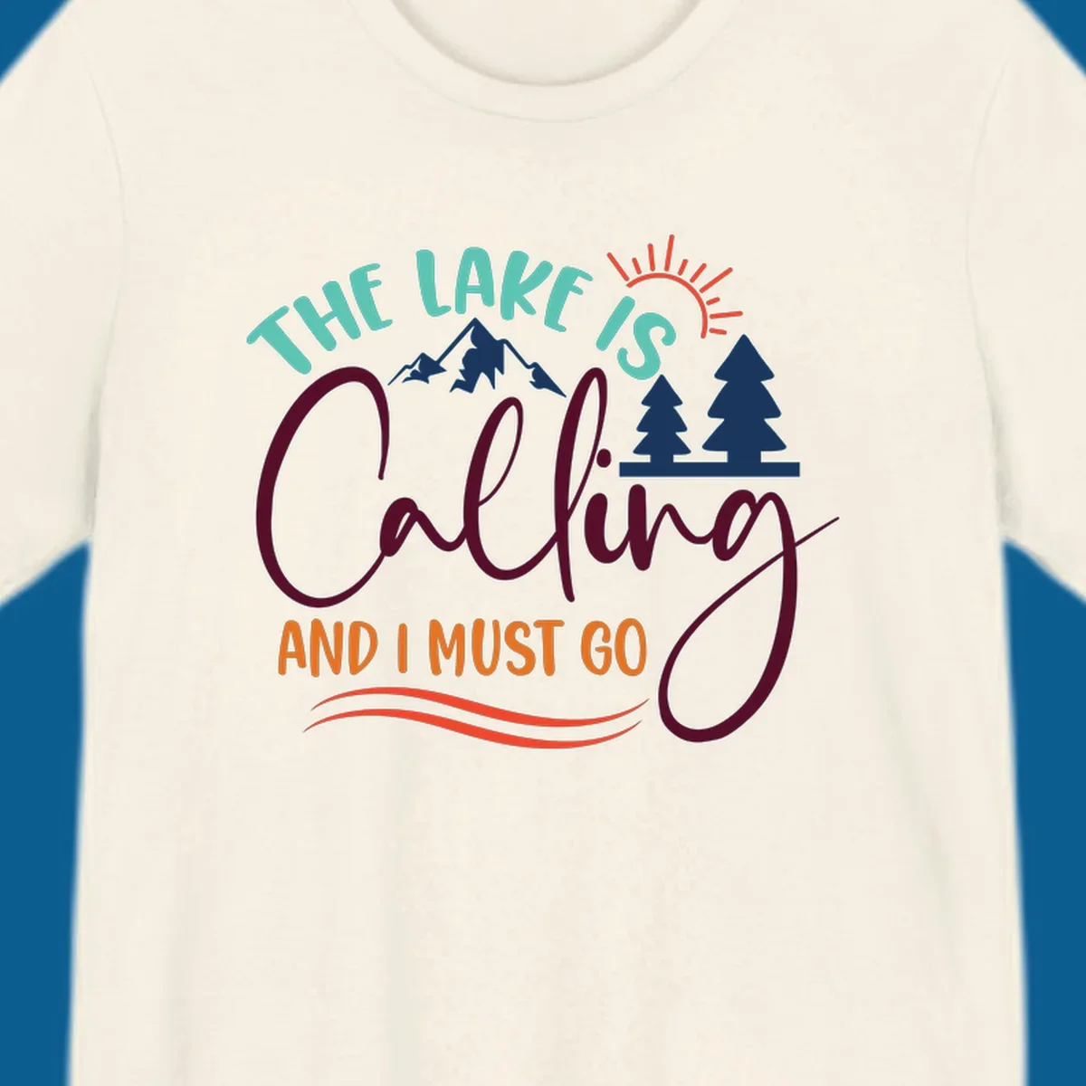 The Lake Is Calling And I Must Go nature graphic with mountains, trees, and sun rays.