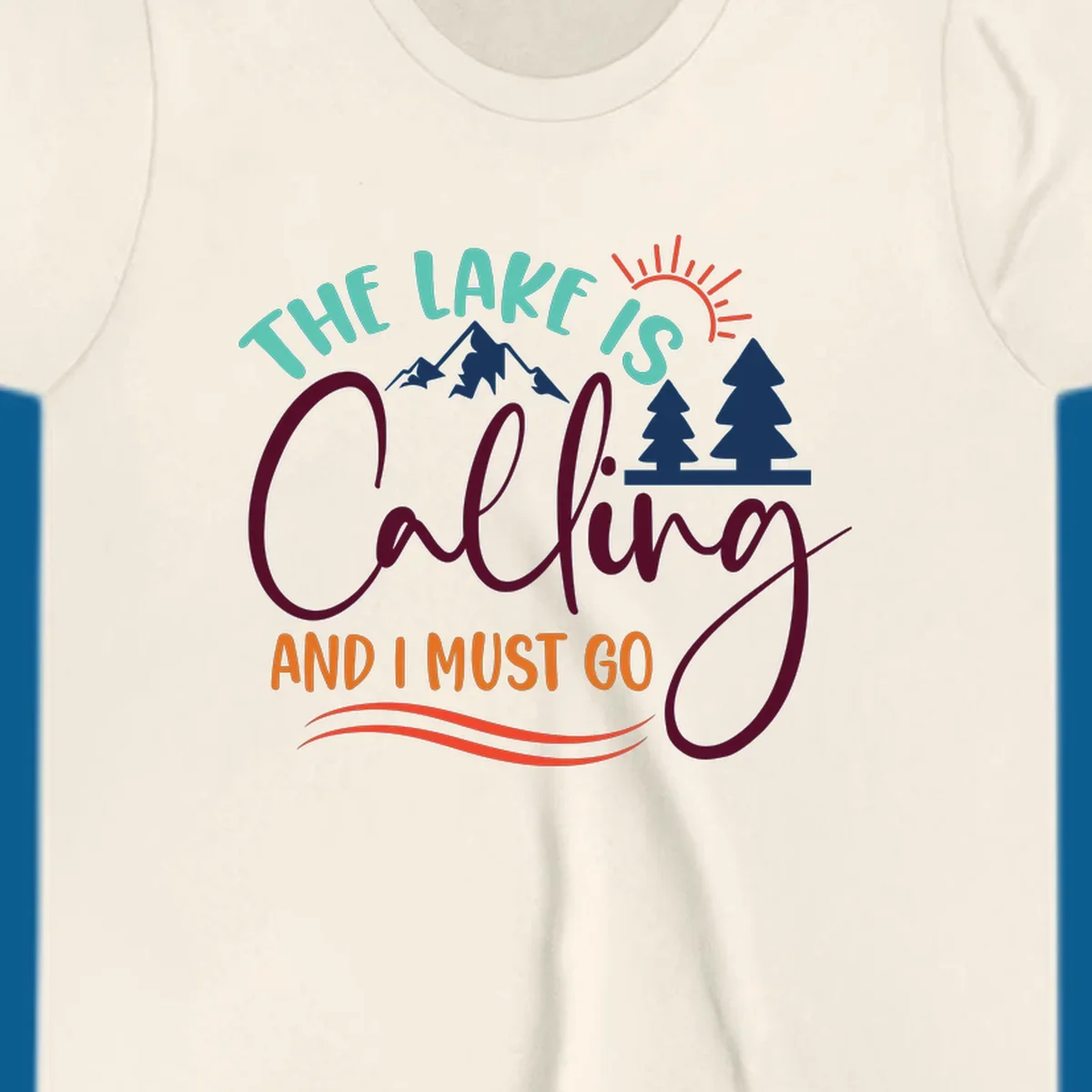 The Lake Is Calling And I Must Go nature graphic with mountains, trees, and sun rays.