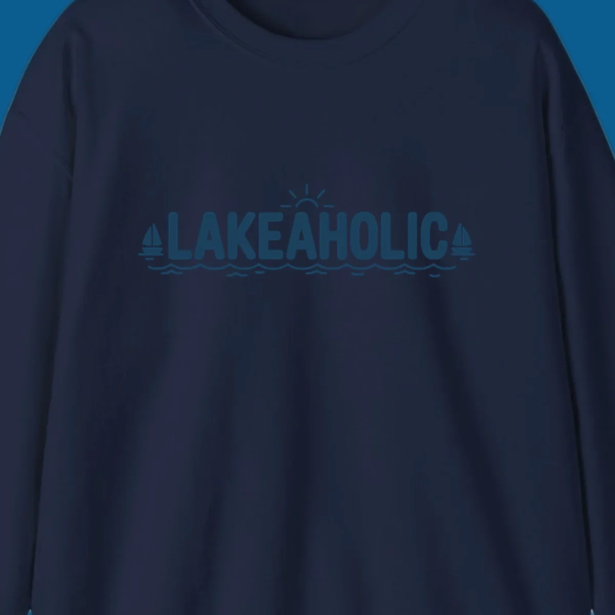 Lakeaholic typography with sun, sailboats, and waves graphic.