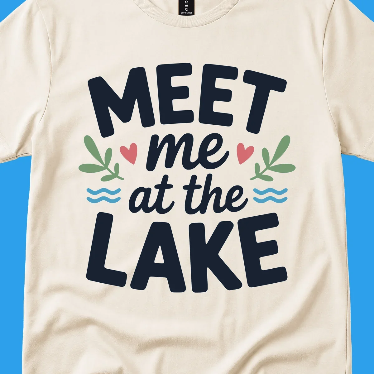 Meet me at the lake typography design with hearts, leaves, and waves.