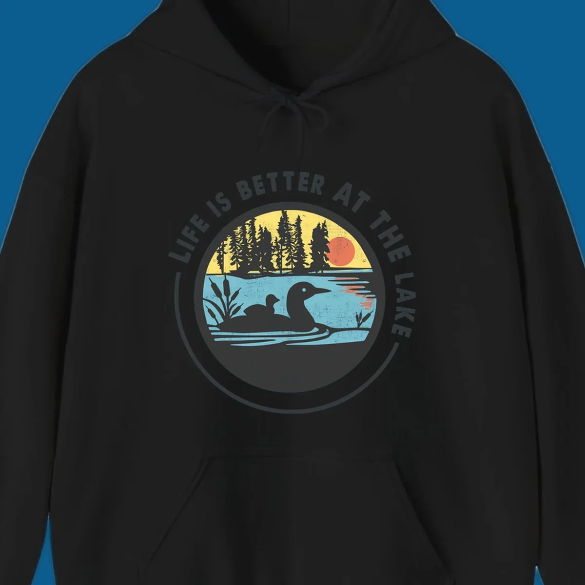 Circular lake scene with loons and trees, text "Life Is Better At The Lake".