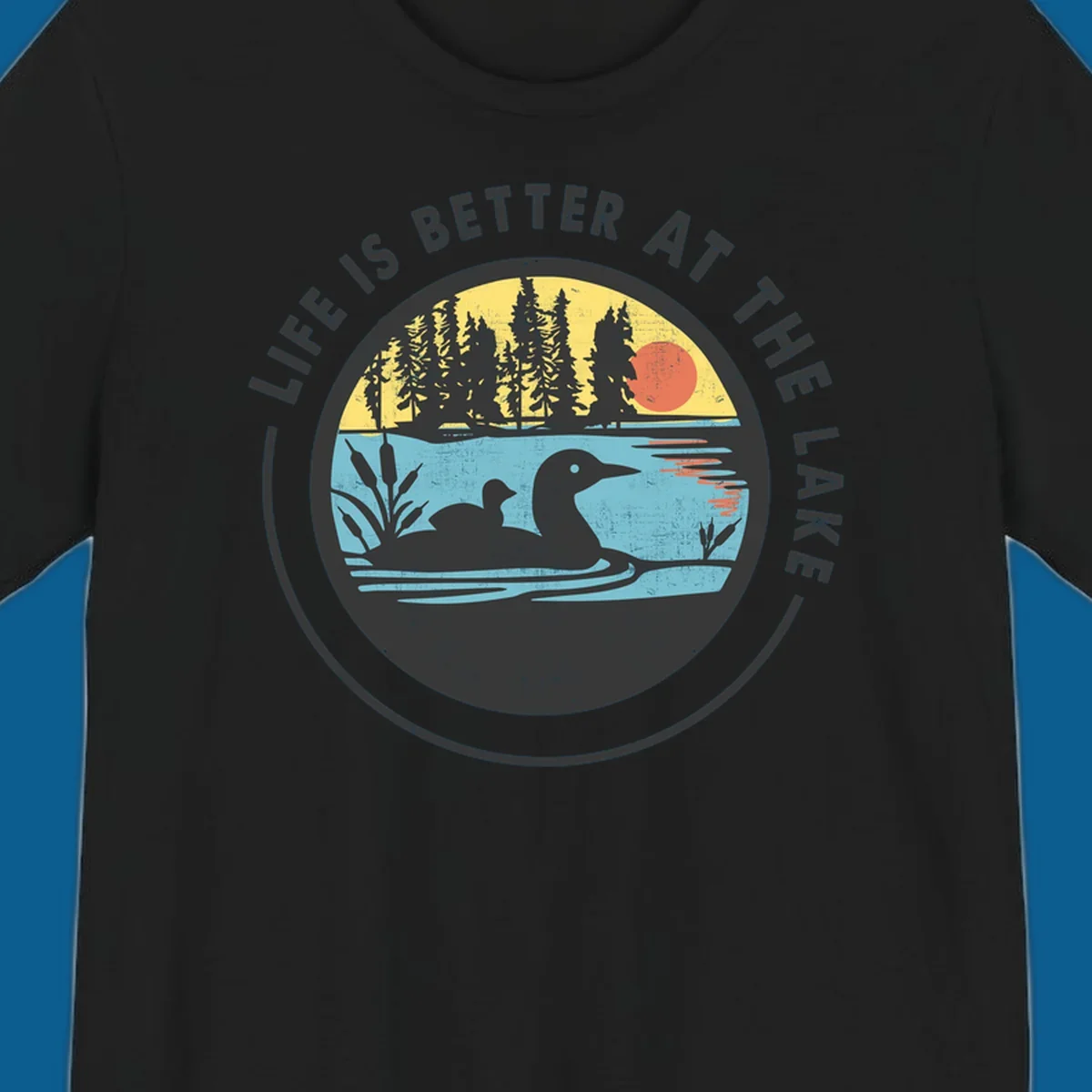 Circular lake scene with loons and trees, text "Life Is Better At The Lake".