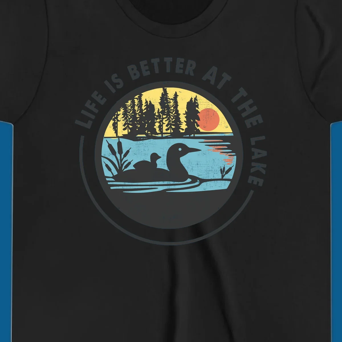 Circular lake scene with loons and trees, text "Life Is Better At The Lake".