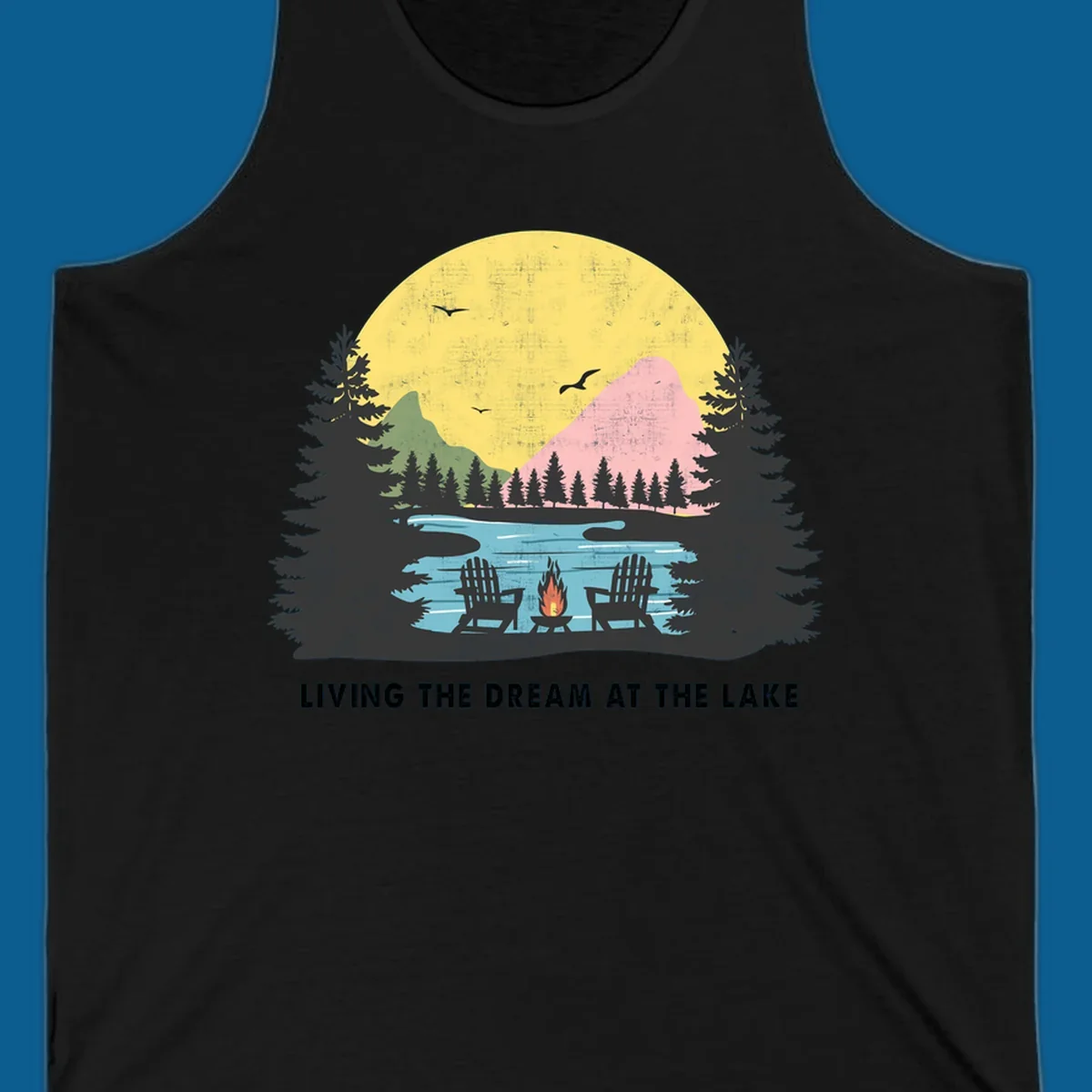 Lake life dream scene with Adirondack chairs, campfire, and sunset over mountains. Text: LIVING THE DREAM AT THE LAKE