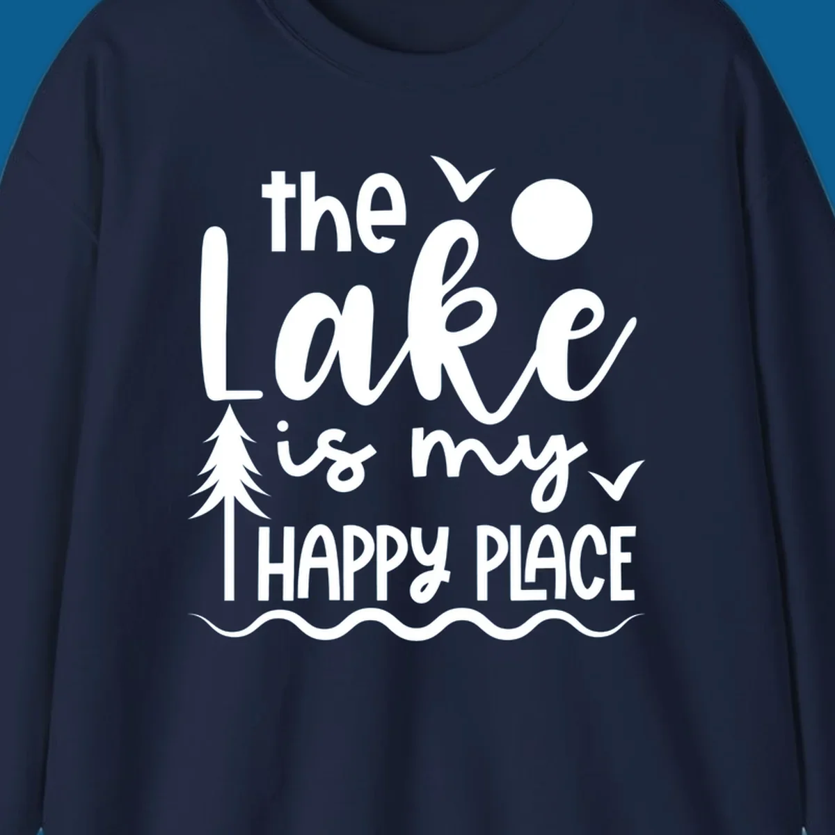 The Lake Is My Happy Place text design with lake elements like a tree, sun, and birds.