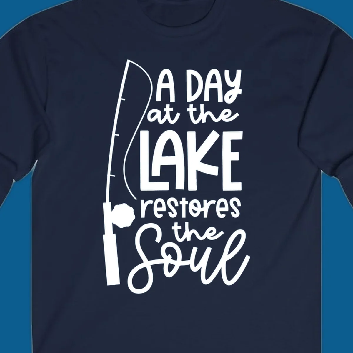Fishing pole with text "A Day at the Lake Restores the Soul", lake-life concept.