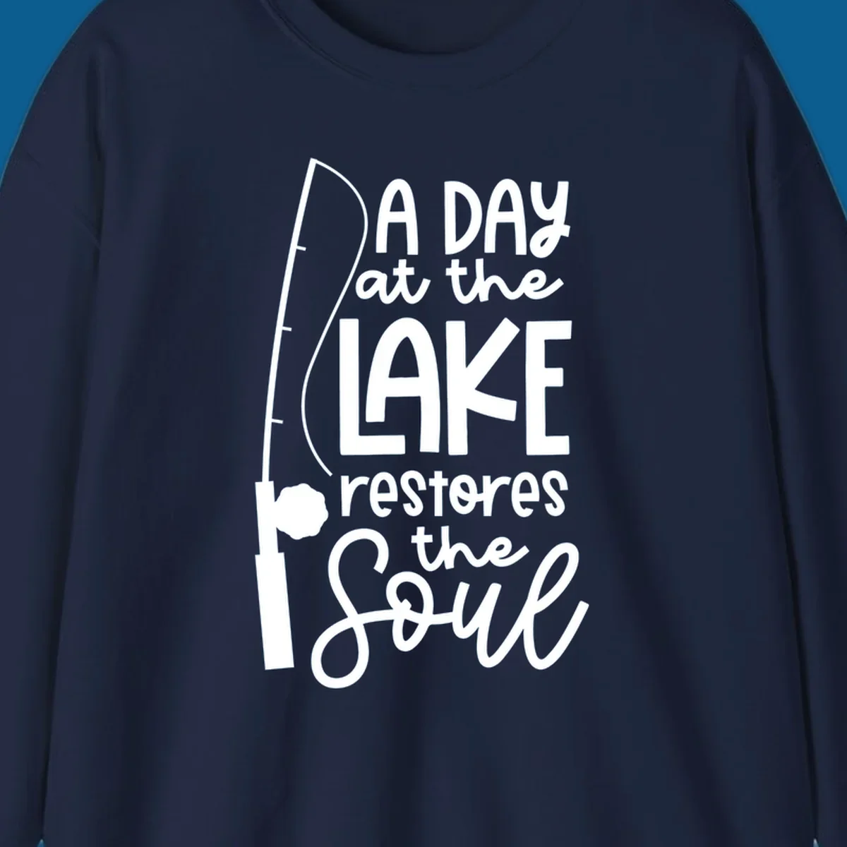 Fishing pole with text "A Day at the Lake Restores the Soul", lake-life concept.