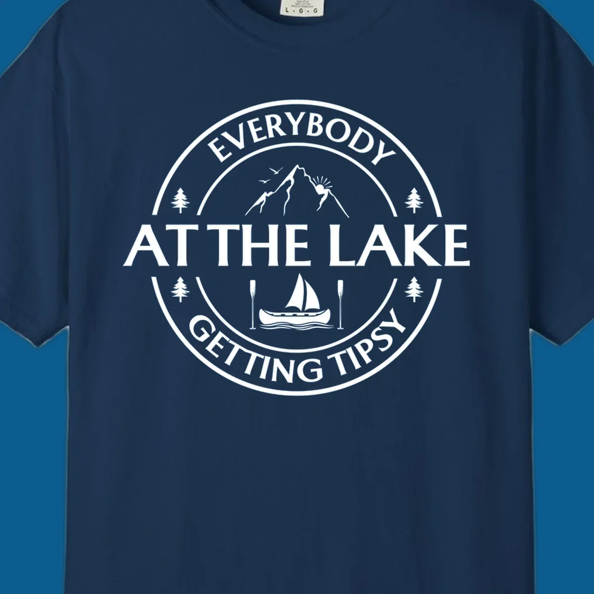 Circular badge design for lake life featuring mountains, canoe, and text 'Everybody At The Lake Getting Tipsy'.