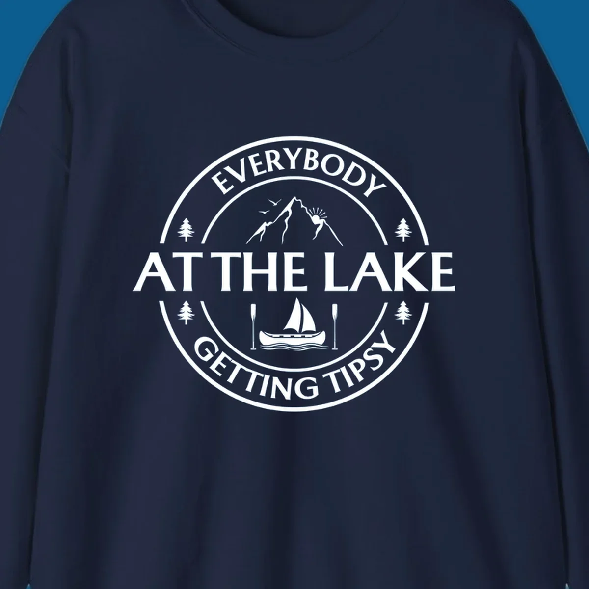 Circular badge design for lake life featuring mountains, canoe, and text 'Everybody At The Lake Getting Tipsy'.