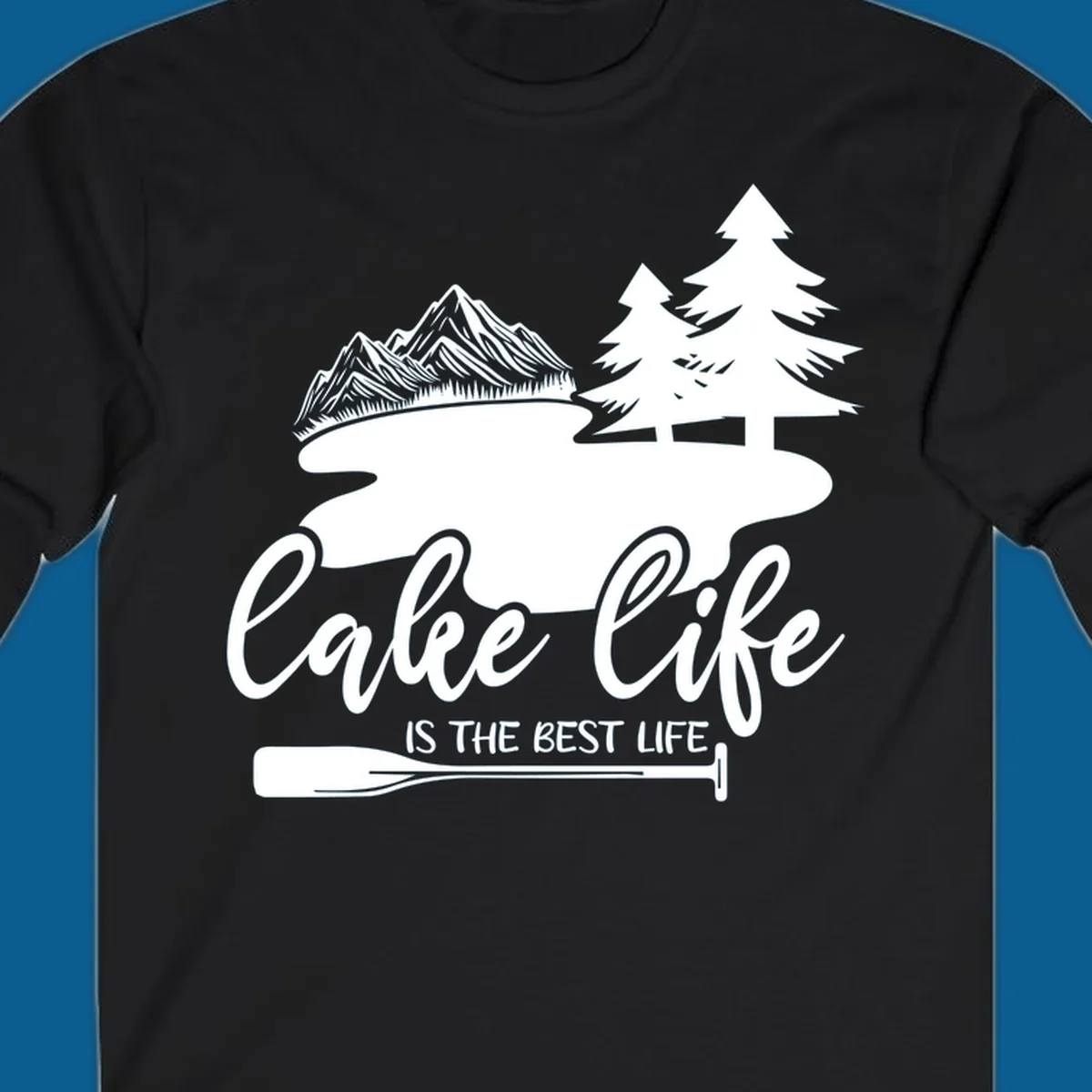 Lake life is the best life design with mountains, trees, lake, and paddle graphic.
