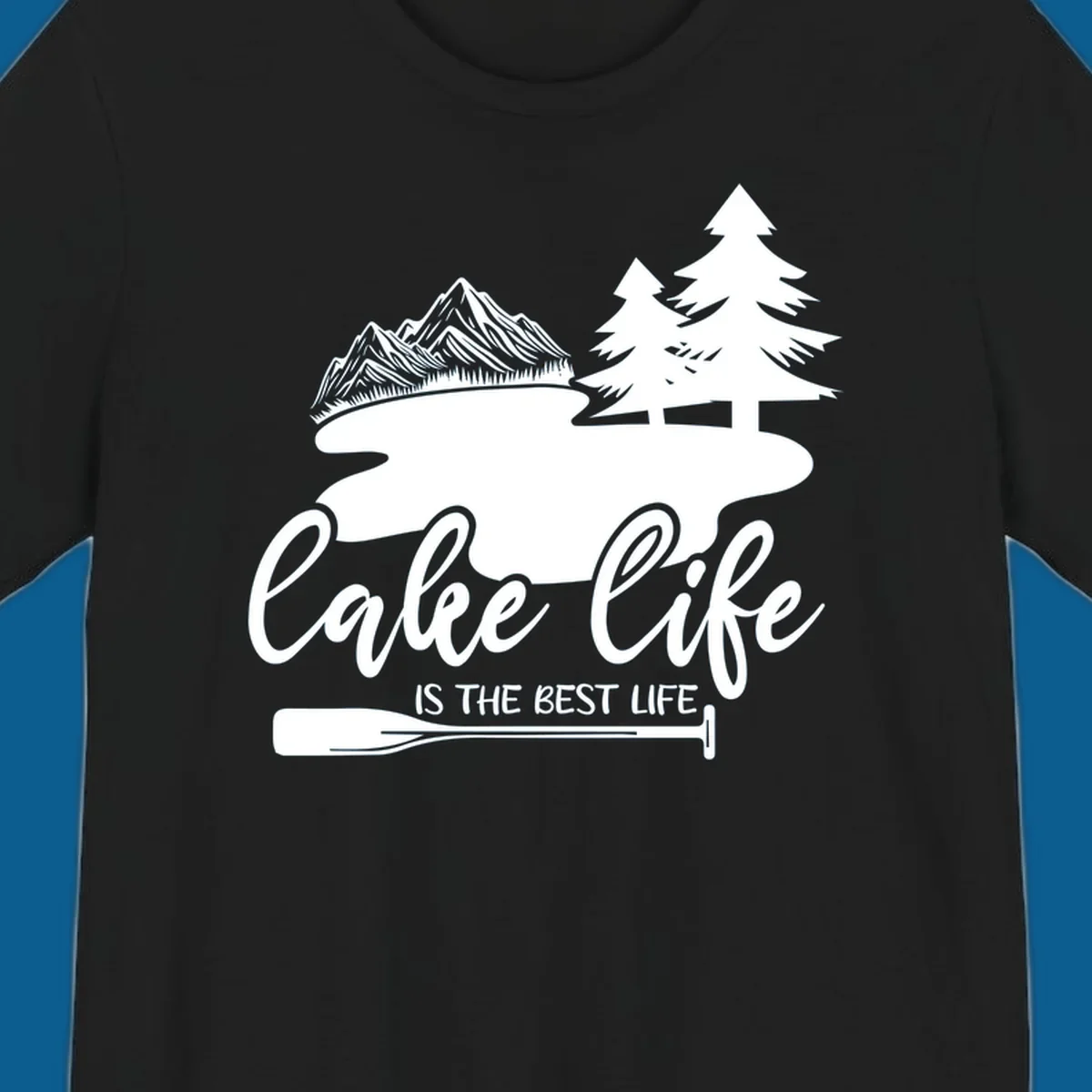 Lake life is the best life design with mountains, trees, lake, and paddle graphic.