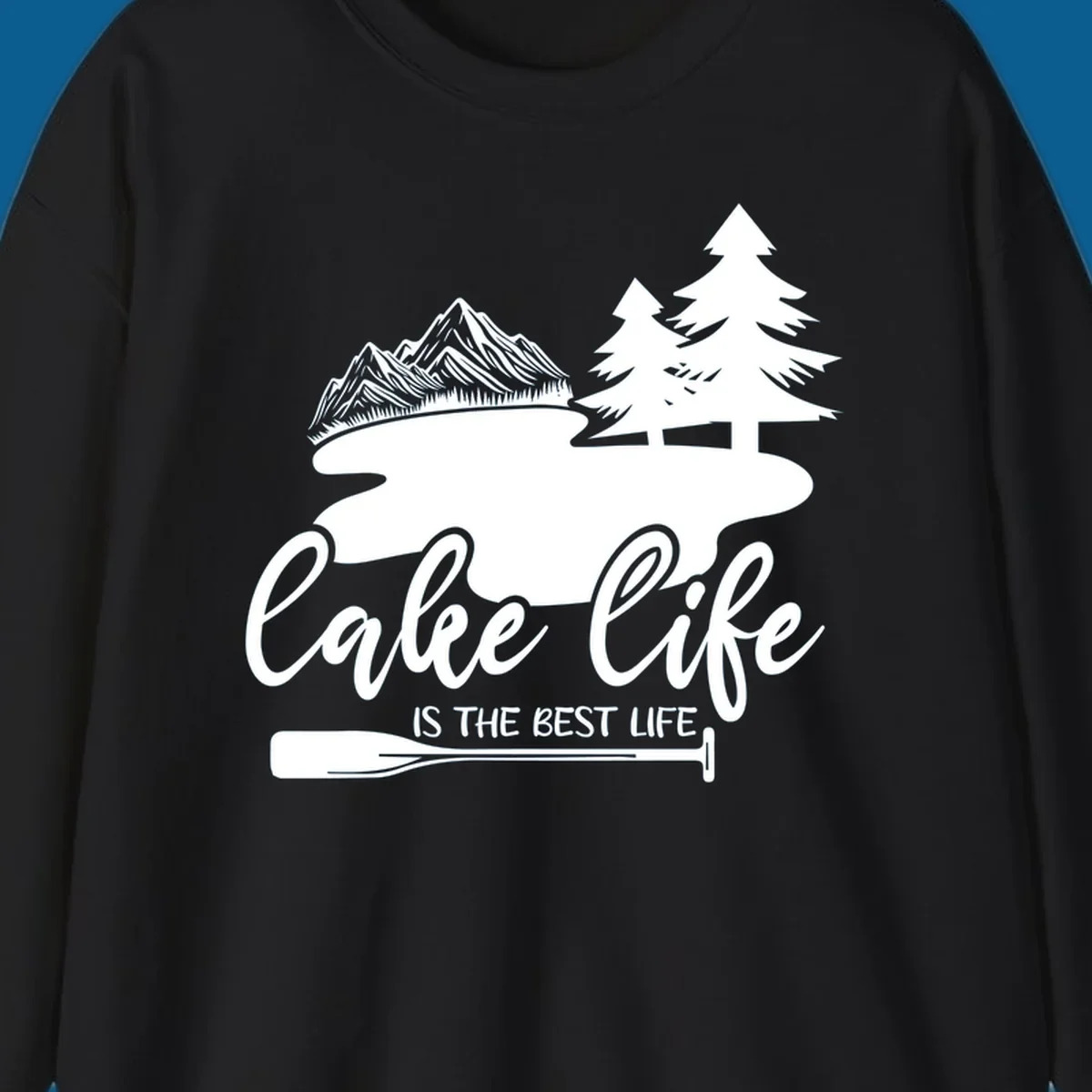 Lake life is the best life design with mountains, trees, lake, and paddle graphic.