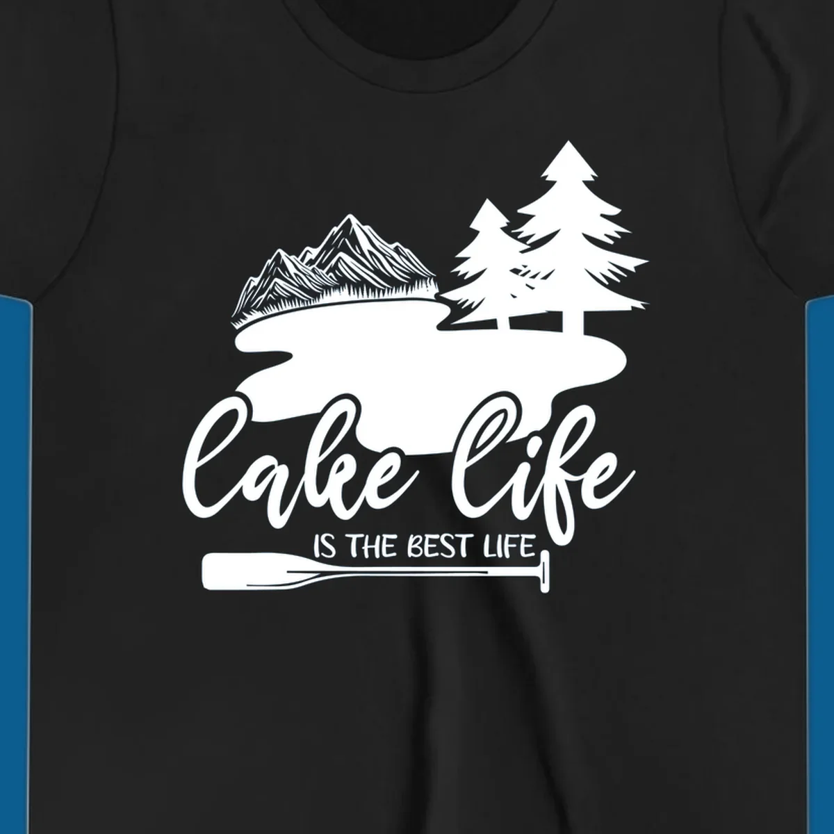 Lake life is the best life design with mountains, trees, lake, and paddle graphic.