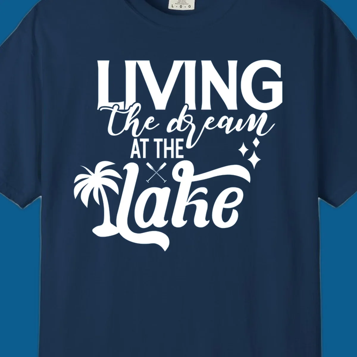 Living the dream at the lake text with palm tree and oars graphic