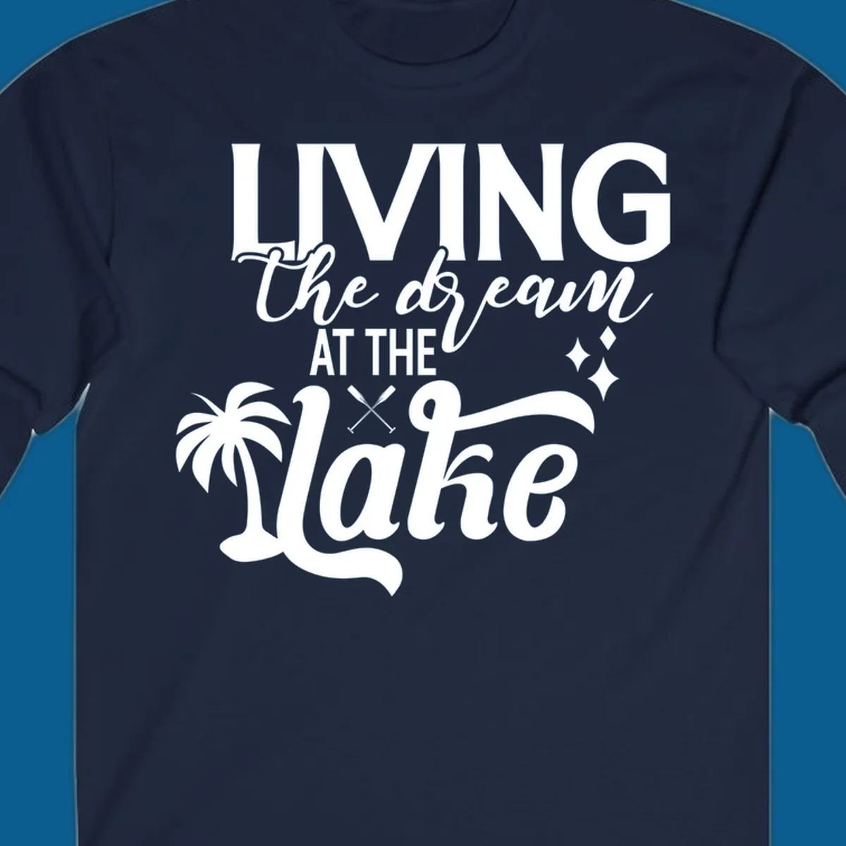 Living the dream at the lake text with palm tree and oars graphic