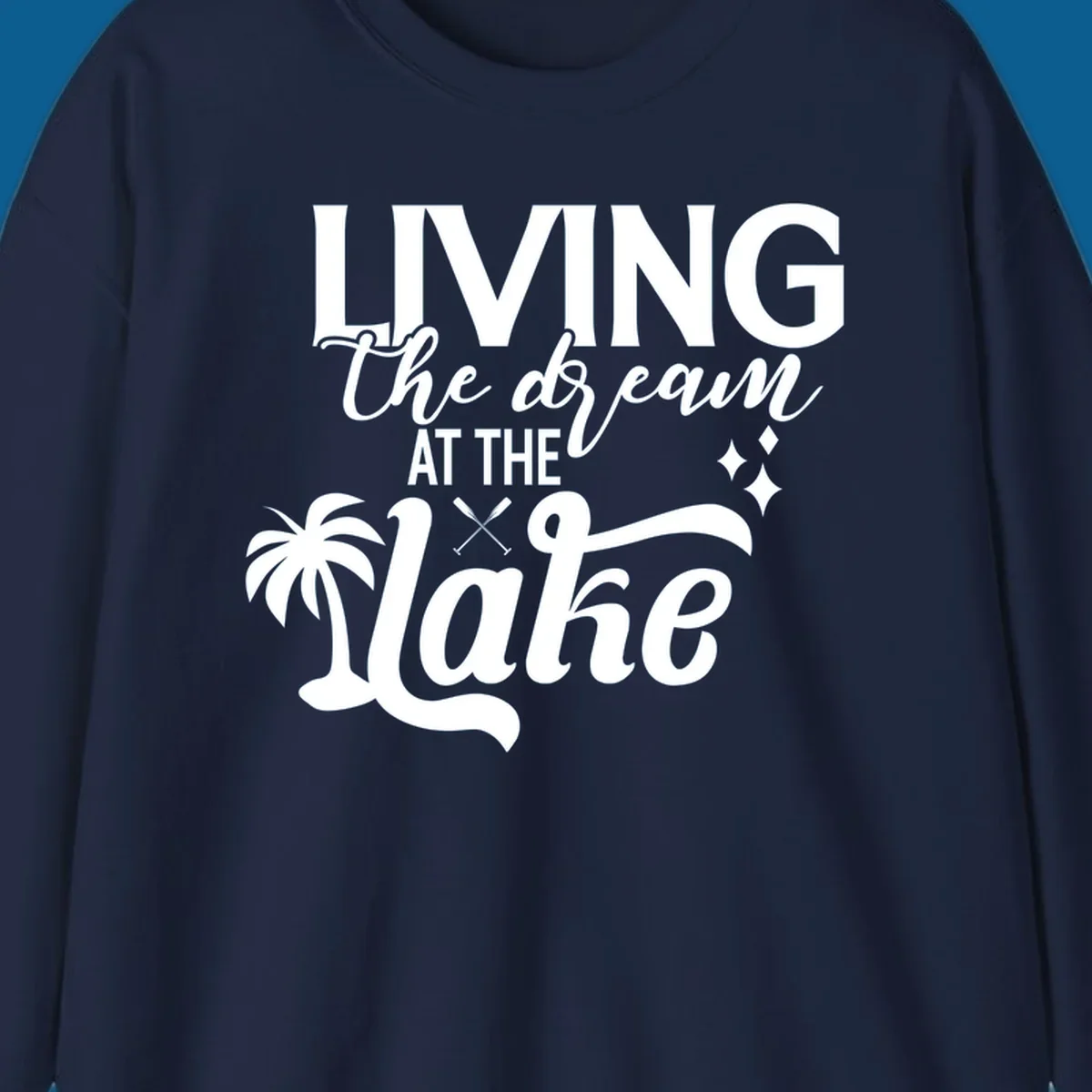 Living the dream at the lake text with palm tree and oars graphic