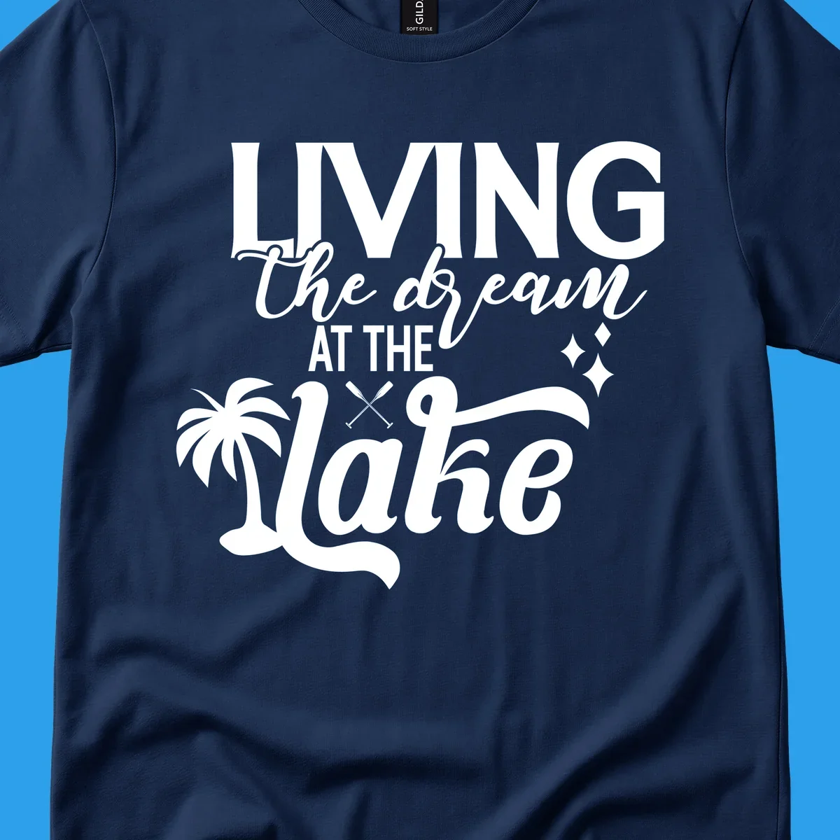 Living the dream at the lake text with palm tree and oars graphic