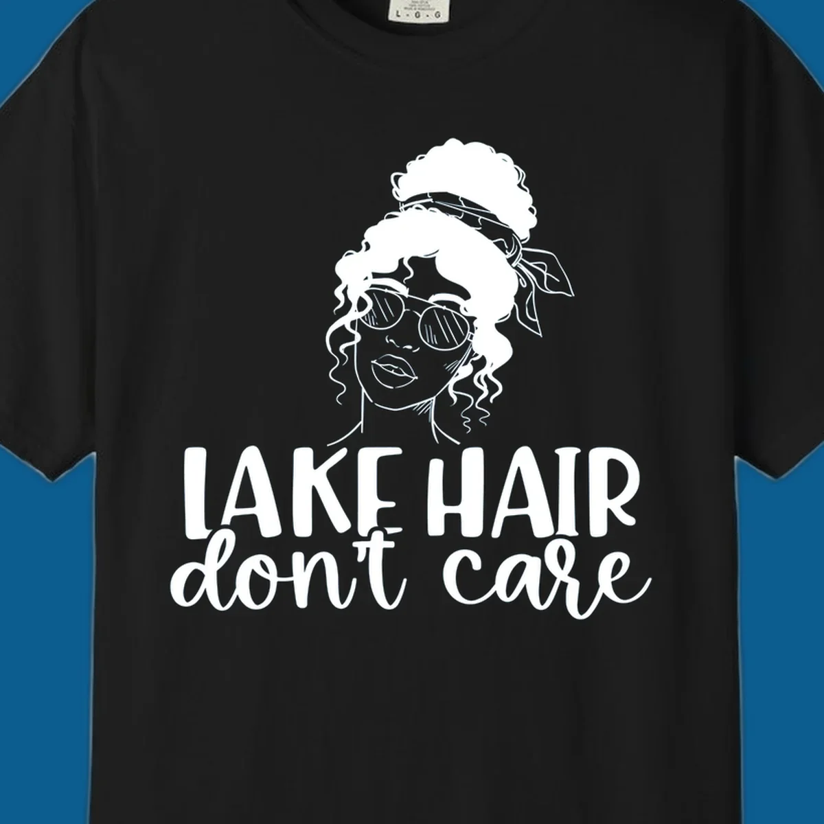 Illustration of a woman with sunglasses and messy bun, with text 'Lake Hair Don't Care'.