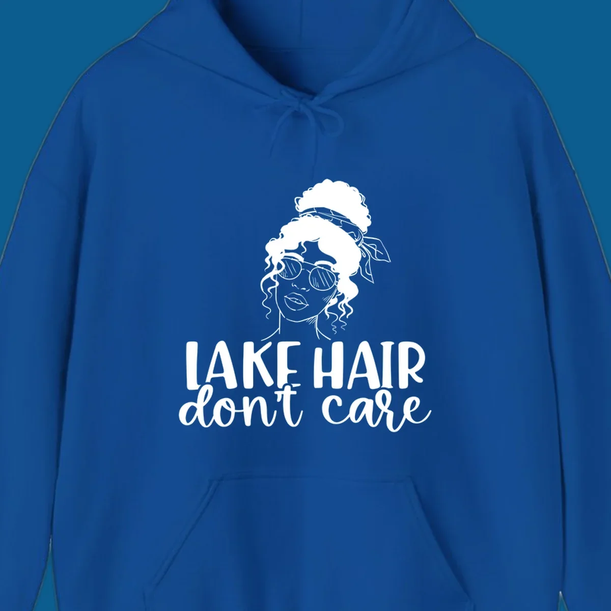 Illustration of a woman with sunglasses and messy bun, with text 'Lake Hair Don't Care'.