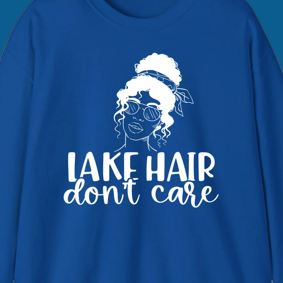 Illustration of a woman with sunglasses and messy bun, with text 'Lake Hair Don't Care'.
