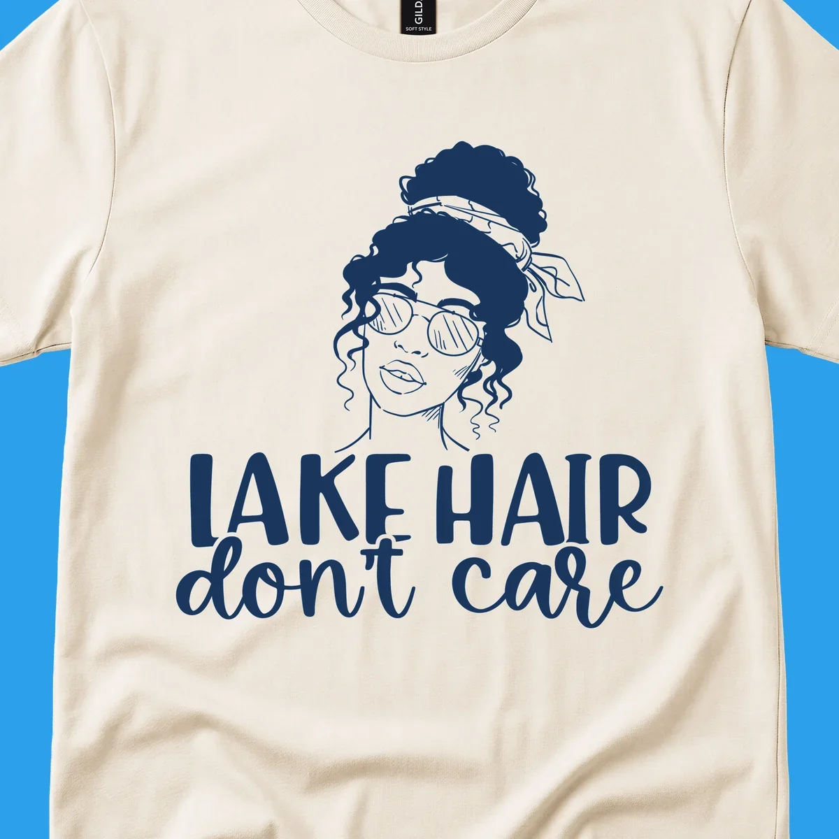 Illustration of a woman with sunglasses and messy bun, with text 'Lake Hair Don't Care'.